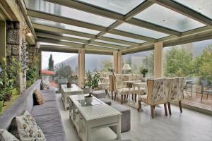 a conservatory with a couch and a table and chairs at Boutique Hotel Skamnos Arachova in Arachova