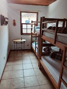 a room with three bunk beds and a table at Hospedaria e Hostel da Déia in Ouro Preto