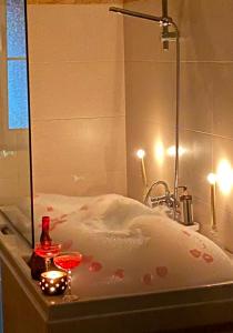 a bath tub with two candles and two glasses in it at Hotel Internacional Gym & Spa Fushe-Arrez in Fushë-Arrëz