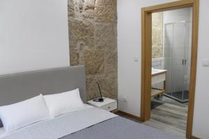 um quarto com uma cama e um banheiro com uma pia em ALOJAMENTO GIRASSOL - Guest House - Quarto com casa de banho privativa em Castelo Branco