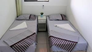 - 2 lits jumeaux dans une petite chambre avec une table dans l'établissement PRAIA RESIDENCE 303A - Porto de Galinhas - PE, à Porto de Galinhas