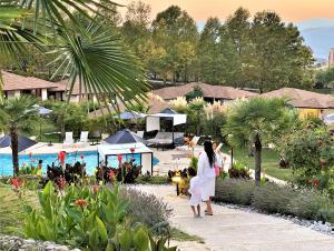 Una donna in bianco che cammina vicino alla piscina in un resort di Medite Spa Resort and Villas a Sandanski