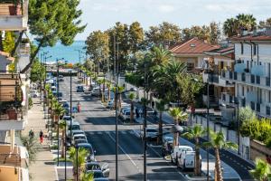 una calle de la ciudad con coches aparcados y palmeras en Anita Domus - Appartamento con vista a Pescara, en Pescara