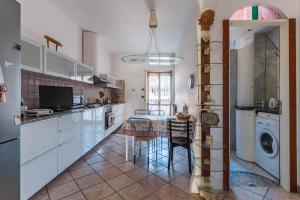 eine Küche mit einem Tisch und einer Waschmaschine in der Unterkunft Anita Domus - Appartamento con vista a Pescara in Pescara