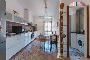 cocina con mesa y lavadora en Anita Domus - Appartamento con vista a Pescara, en Pescara