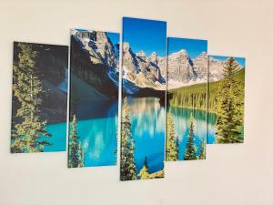 a painting of a mountain lake and trees on a wall at Elbflair in Pirna