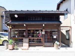 ein Geschäft mit Markise und Pflanzen vor einem Gebäude in der Unterkunft Tabino Shiori - Vacation STAY 83814 in Takayama