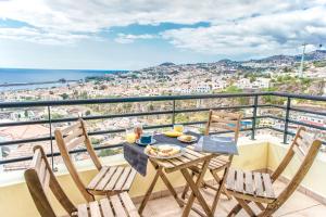 stół i krzesła na balkonie z widokiem na miasto w obiekcie Trendy Apartments w Funchal