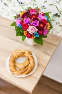 a table with a bowl of flowers and a pretzel at Vintage Tomasza 25 Apartments in Krakow