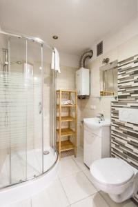 uma casa de banho com um chuveiro, um WC e um lavatório. em Vintage Tomasza 25 Apartments em Cracóvia