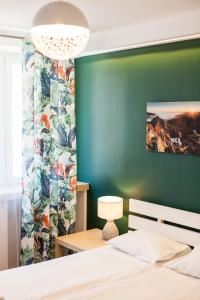 um quarto com uma cama e uma parede verde em Vintage Tomasza 25 Apartments em Cracóvia