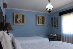 ポンテ・デ・リマにあるCasa das Andorinhasの青いベッドルーム(ベッド2台、窓付)
