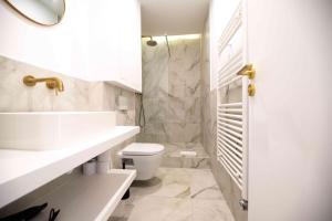 a white bathroom with a toilet and a sink at Luxury Residence - Paris South in Montrouge