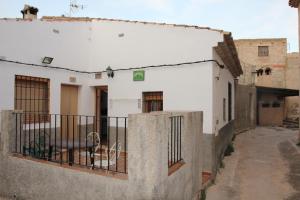 un edificio con recinzione e un cane sul balcone di Casa Rural Manuel y Dolores a Letur