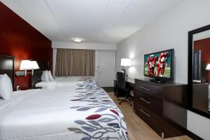 a hotel room with a bed and a flat screen tv at Red Roof Inn Bloomington - Normal/University in Bloomington
