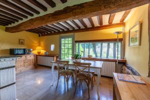 - une cuisine avec une table et des chaises dans la chambre dans l'établissement Le Manoir du Perroy, à Saint-Wandrille-Rançon