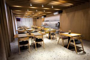 a restaurant with wooden tables and chairs and a kitchen at Hotel Novy Kastiel - Self check-in in Topoľčany