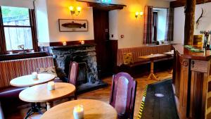 a restaurant with tables and chairs and a fireplace at The Coylet Inn by Loch Eck in Dunoon