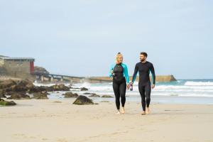 a man and woman walking on the beach at The Old Success Inn in Sennen Cove