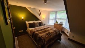 Un pat sau paturi într-o cameră la The Coylet Inn by Loch Eck