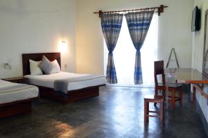 a bedroom with two beds and a desk and a window at Casa Losodeli & Coworking- Adults Only in Puerto Escondido