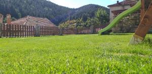 a yard with a wooden fence and a green lawn at Valkanovi House in Pamporovo
