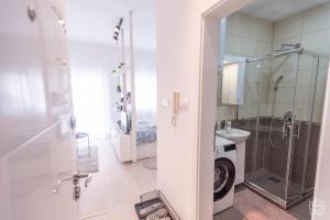 een badkamer met een douche en een wastafel bij Apartman Bombonica in Banja Koviljača