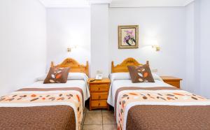 a bedroom with two beds and a nightstand and two beds at Tierra de la Reina in Boca de Huérgano