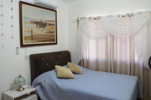 una camera da letto con un letto blu e una finestra di SCHUCH - POUSADA a Treze Tílias