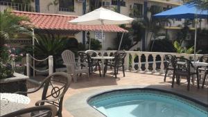 a pool with chairs and tables and an umbrella at Arcos hotel in Catemaco