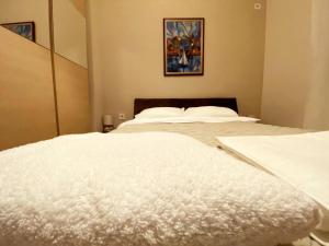 1 dormitorio con 2 camas blancas con una foto en la pared en Апартамент МИТИ en Pleven
