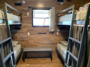 a room with bunk beds and a table and a window at Jasper Downtown Hostel in Jasper