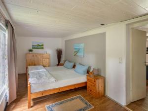 a small bedroom with a bed and a wooden cabinet at Quaint Holiday Home near Forest in Stuer in Stuer