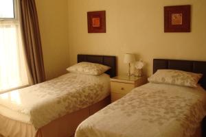 1 dormitorio con 2 camas y ventana en Wendover Guest House, en Bolton