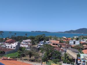 Una ciudad con casas y el océano en el fondo en Apartamento Família Santos, en Penha