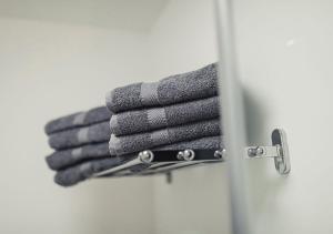 a stack of towels on a rack in a bathroom at Ferienwohnungen und Boardinghouse Heimbach in Lahr in Lahr