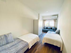 a small bedroom with two beds and a couch at La Casa de los Álamos in Málaga