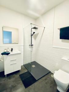 uma casa de banho com uma cabina de duche em vidro e um WC. em La Casa de los Álamos em Málaga
