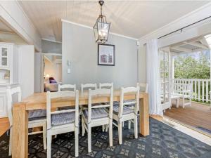 - une salle à manger avec une table et des chaises en bois dans l'établissement Lou Lous Cottage Bowral Southern Highlands, à Bowral