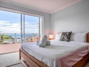 1 dormitorio con 1 cama grande y vistas al océano en Kitesurfer Gerroa, en Gerroa