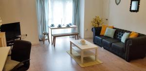 sala de estar con sofá y mesa en Sun Gardens Serviced Apartment, en Thornaby on Tees