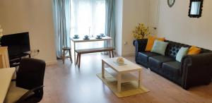 a living room with a couch and a table at Sun Gardens Serviced Apartment in Thornaby on Tees