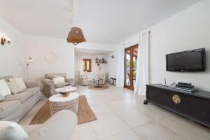 a living room with a couch and a tv at Black and white Cat Villa in Pollença