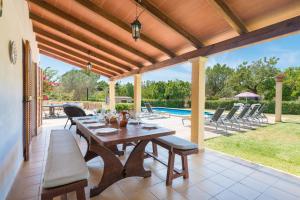 a patio with a table and chairs and a pool at Black and white Cat Villa in Pollença