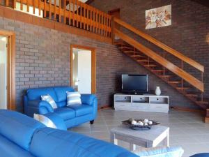 een woonkamer met blauwe banken en een trap bij Pinkos Gerroa in Gerroa