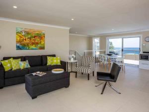 a living room with a couch and a table at Peninsula 180 Gerroa in Gerroa +14 photos