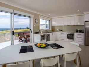 una cocina con una mesa con un bol de fruta. en Peninsula 180 Gerroa, en Gerroa