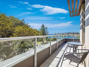 balcón con mesa, sillas y vistas al océano en Sebel Harbourside 301 Kiama en Kiama