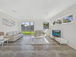 a living room with a couch and a tv at Sea Mist Gerringong in Gerringong