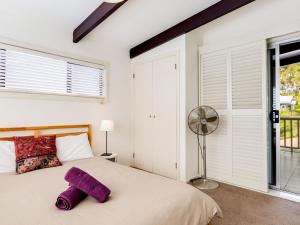 a bedroom with a bed with a purple stuffed animal on it at Shanti at Hyams Beach in Hyams Beach